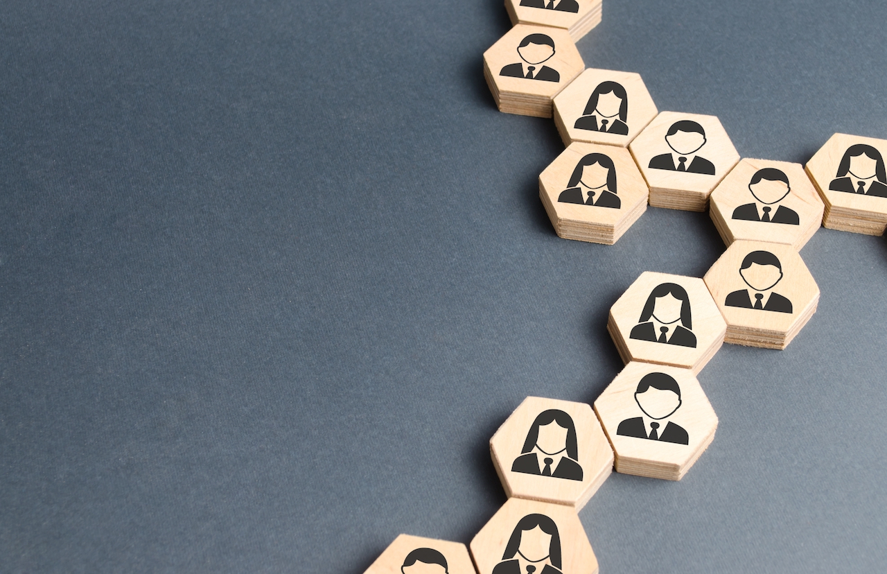 Wood blocks with drawings of employees showing supply chain management.