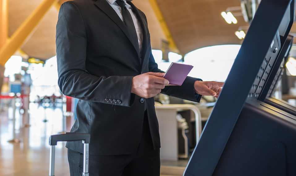 Office visitor using a self-service check-in kiosk at reception